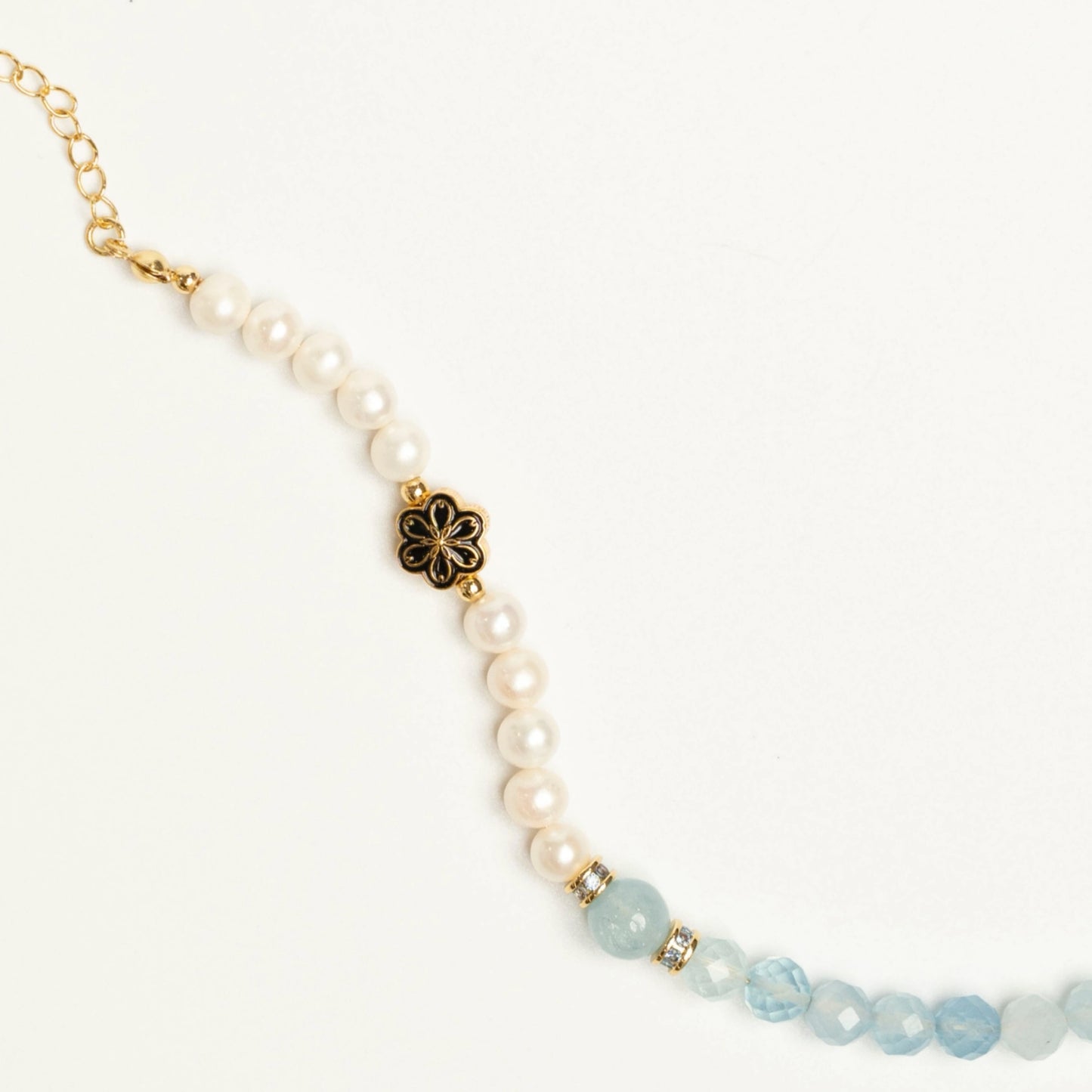 A March-born individual wearing the Mulstio Aquamarine and Pearl bracelet, a personalized talisman that brings a sense of serene confidence to everyday life.