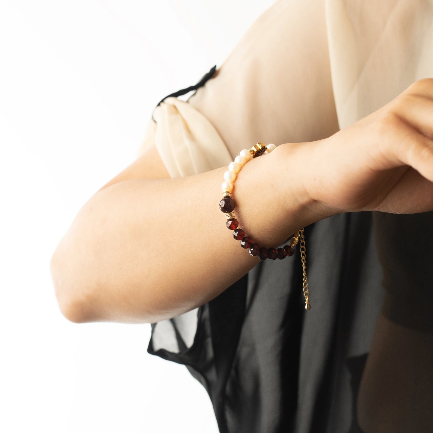 The Mulstio Garnet and Pearl Bracelet, featuring a vibrant garnet stone for passion and a luminous pearl for calm, creating a beautiful balance of energy.