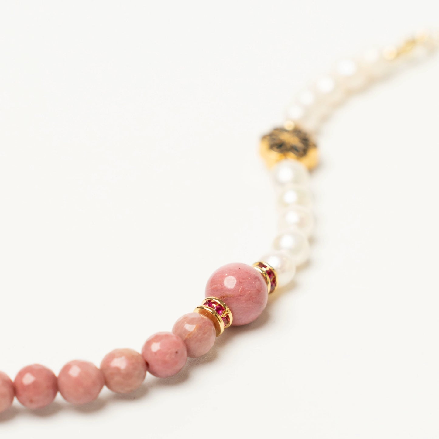 Close-up of the unique bracelet, showcasing the soothing peach-pink hue of the Inca Rose stone contrasted with the soft luster of the Pearl.