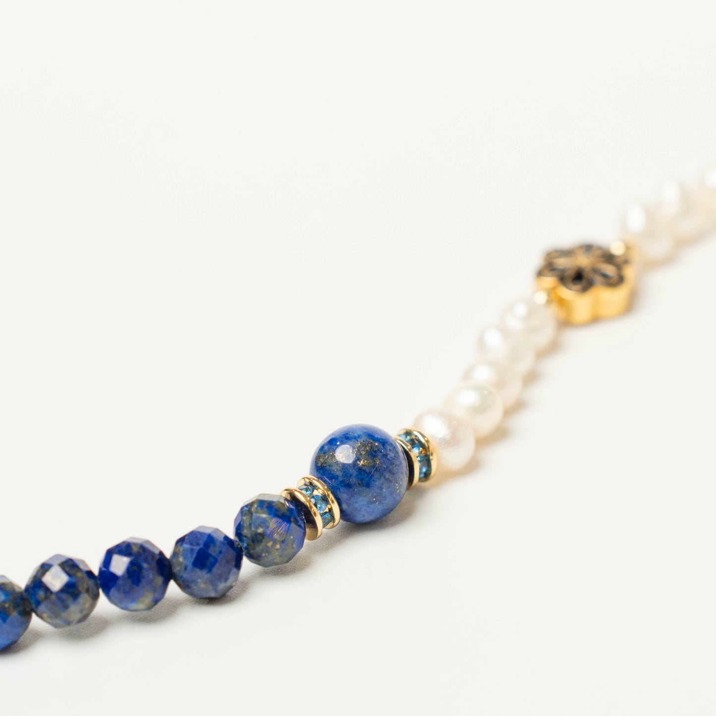 Close-up of the striking spliced design, showcasing the deep celestial blue of Lapis Lazuli with its golden pyrite flecks, elegantly alternating with smooth, glowing Pearls.