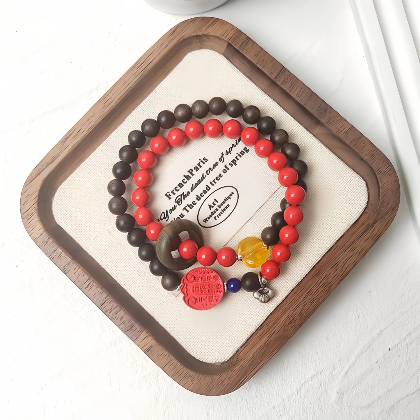 A modern woman wearing the double-wrap Agarwood and Cinnabar bracelet on her wrist.