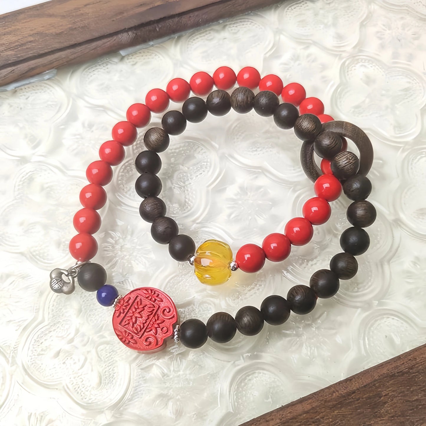Close-up of the Double Wealth Flow bracelet, showing the wooden Agarwood beads and red Cinnabar beads.