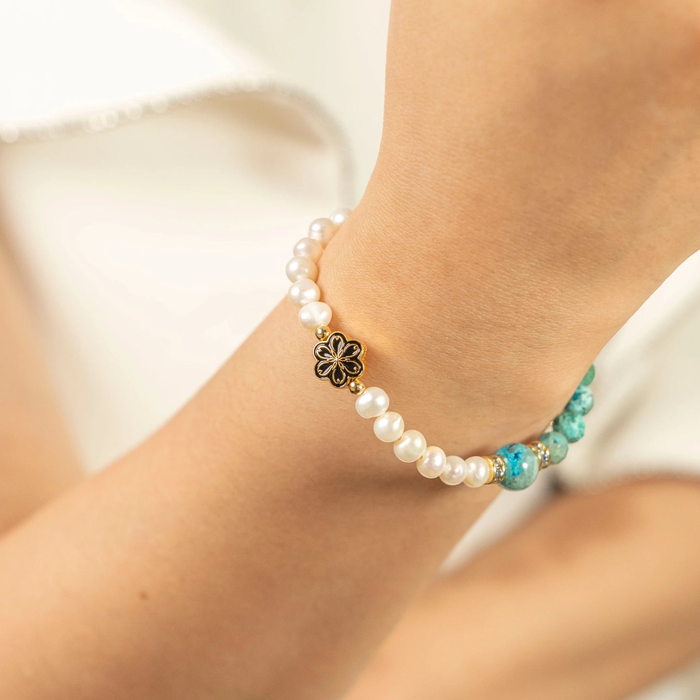 A lady wearing the December Turquoise and Pearl birthstone bracelet on their wrist.