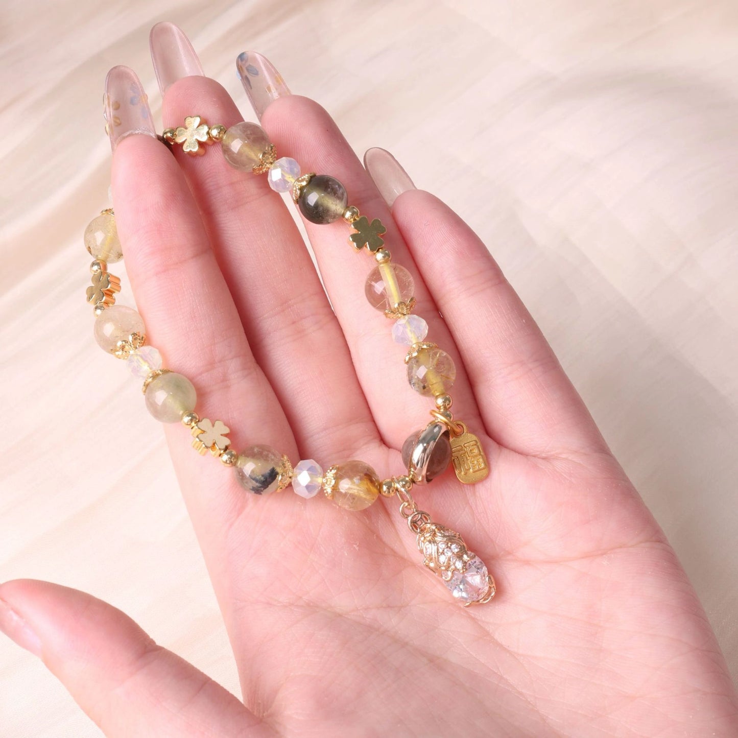 Close-up detail of the Pixiu charm on a yellow crystal bracelet.