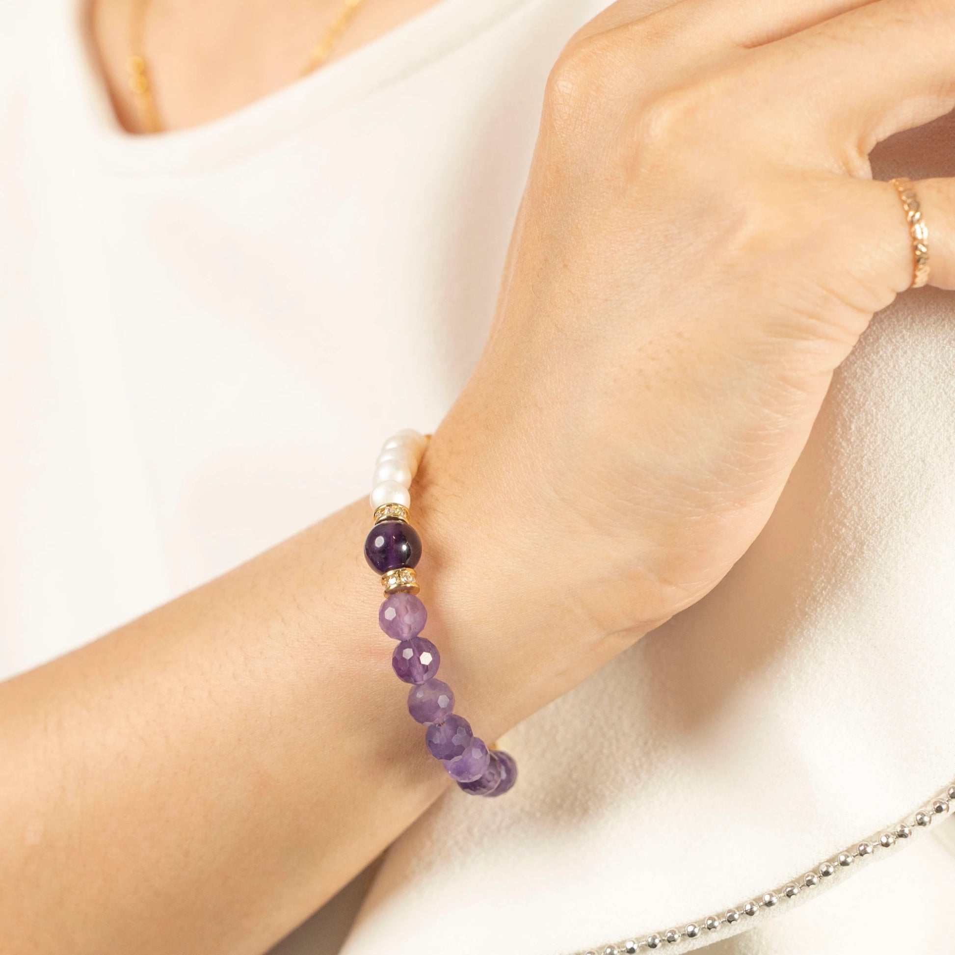 Close-up of the Mulstio bracelet showing the vibrant purple Amethyst and lustrous Pearl beads, hand-strung on a delicate, adjustable chain.