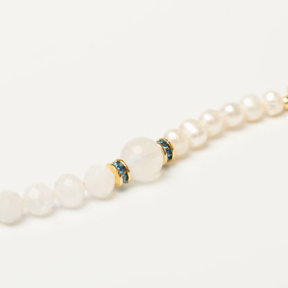 Close-up of the elegant bracelet, showcasing the ethereal blue sheen of the Moonstone bead next to the luminous glow of the Pearl, creating a soft, magical aesthetic.