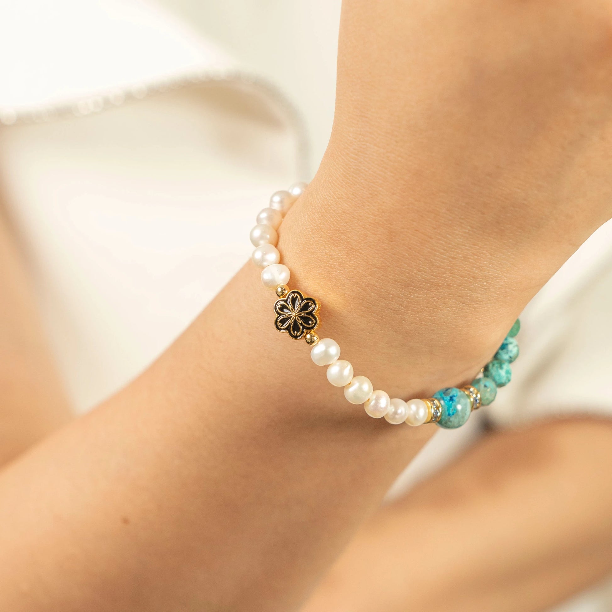 A lady wearing the December Turquoise and Pearl birthstone bracelet on their wrist.