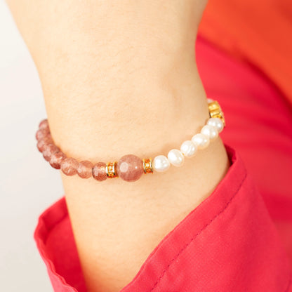 A person radiating positivity and a light heart, wearing the Mulstio Strawberry Quartz and Pearl bracelet as a symbol of their commitment to joyful living.